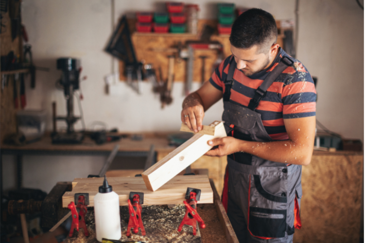 Man spreading glue onto wooden board